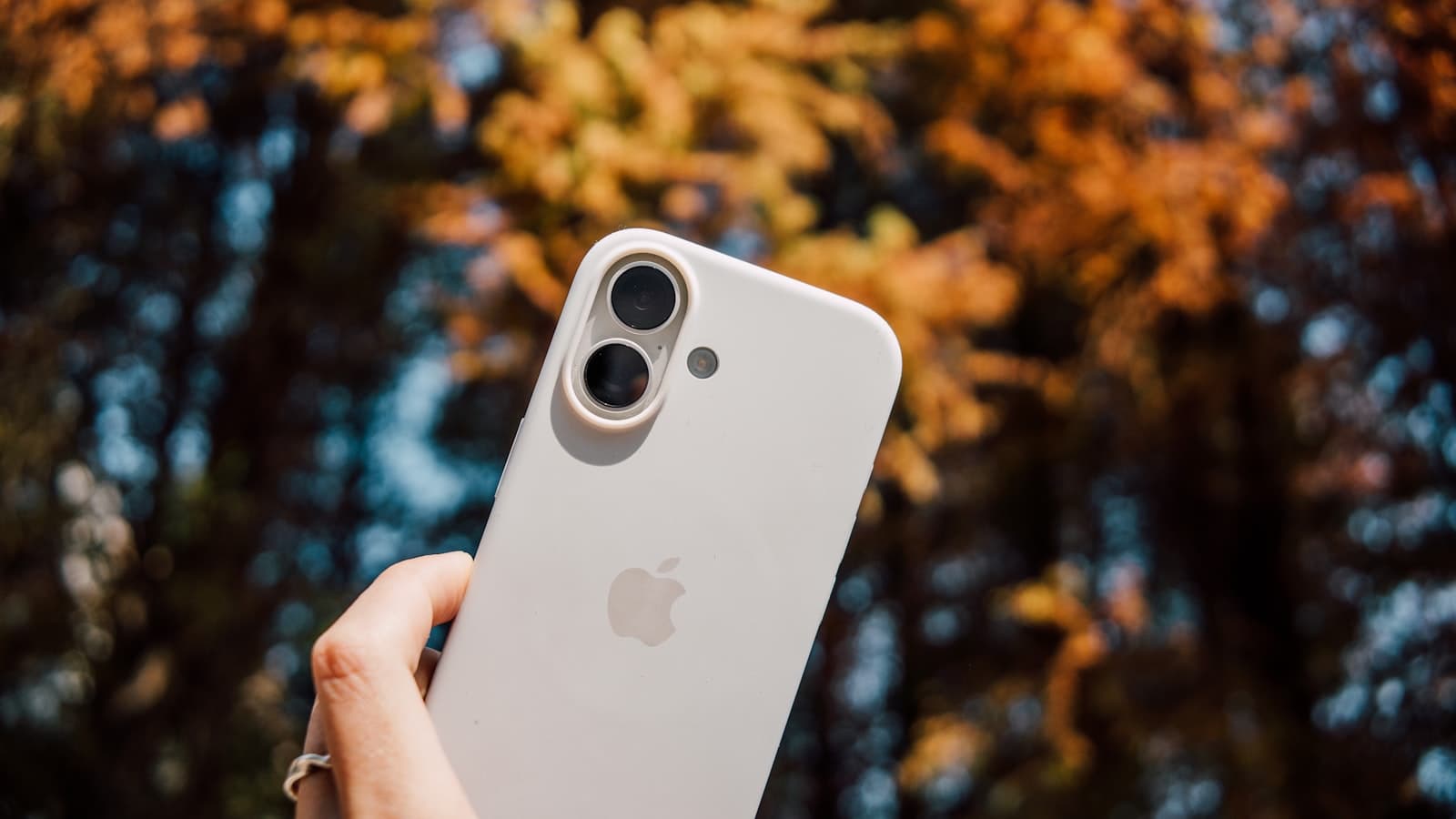 A person holding up an iPhone outdoors